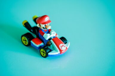 red haired man riding red and blue car plastic toy