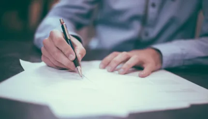 man writing on paper