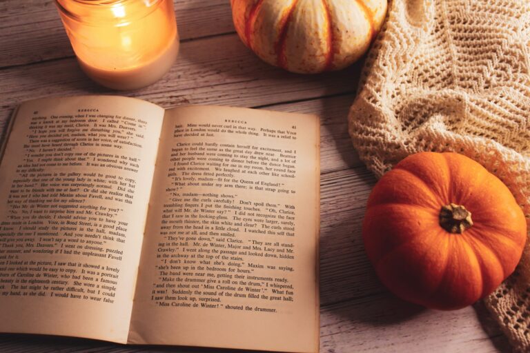 a book and a couple of pumpkins on a table