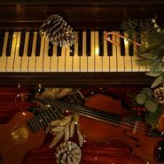 a violin and a pine cone sit on a piano