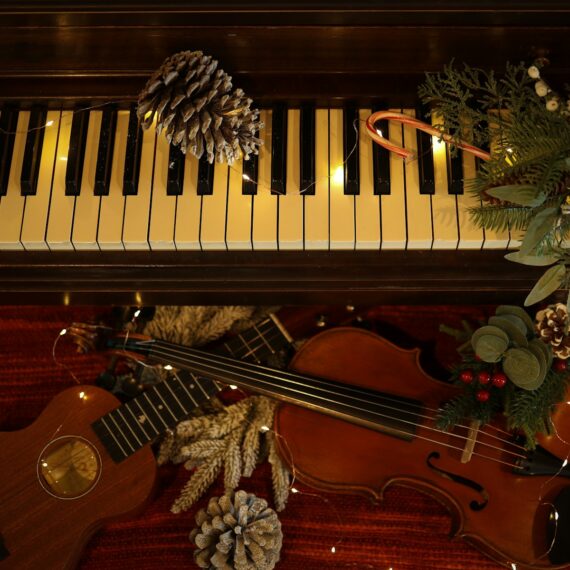 a violin and a pine cone sit on a piano